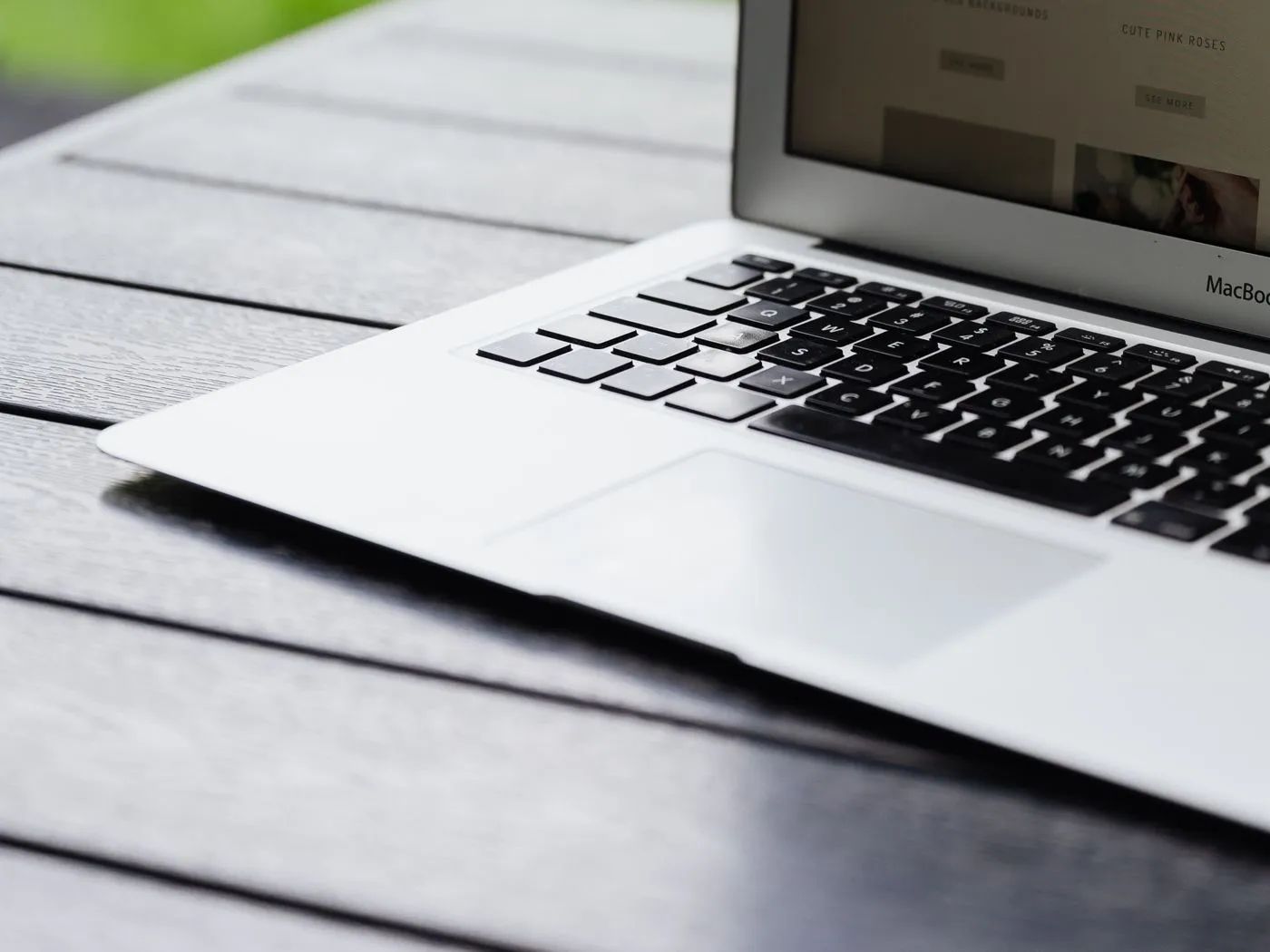 Een opengeklapte laptop op een tafel met een website op het scherm.